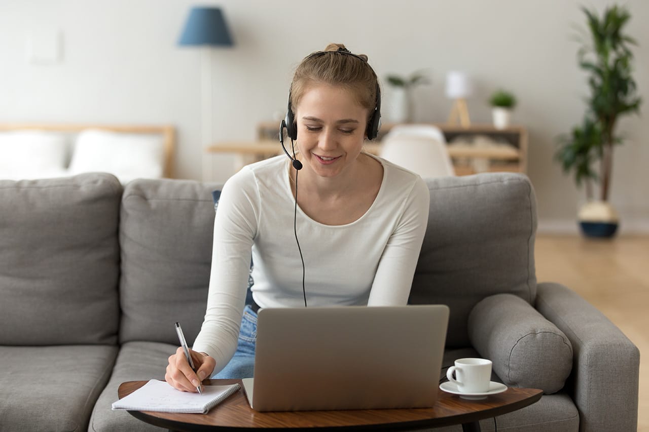 Young female in headset meditating at laptop from home